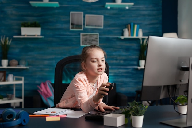 Aluno do ensino fundamental cansado, participando de uma aula online em casa