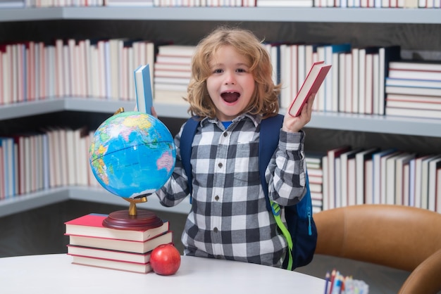 Aluno entusiasmado de volta à escola Menino engraçado da escola primária com o livro Educação