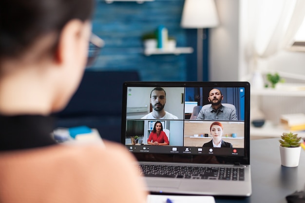 Aluno estudando curso de estilo de vida com seu grupo escolar durante uma reunião de videochamada online usando um computador portátil. Jovem tendo educação à distância durante quarentena de coronavírus