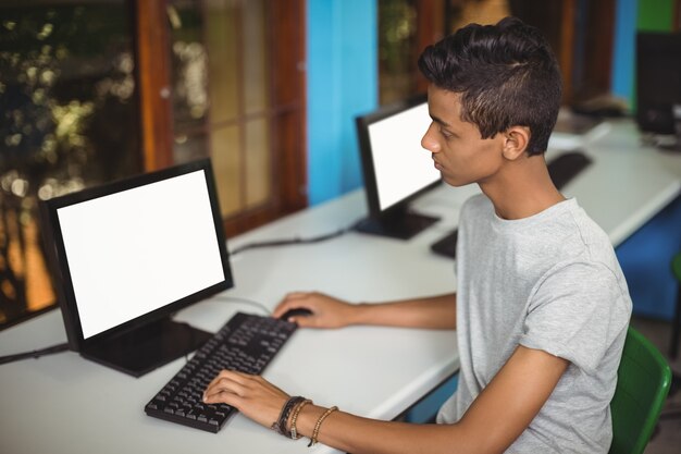 Aluno estudando em sala de aula de informática