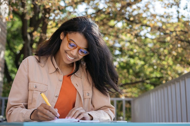 Aluno sorridente, estudando, aprendendo línguas, escrevendo, o conceito de educação