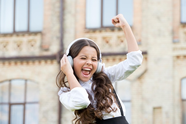 Aluno sorridente Sucesso real Canção feliz Lazer e descanso Penteado lindo Criança feliz ao ar livre Aluna alegre Aluna relaxando Conceito de infância feliz Dia internacional das crianças