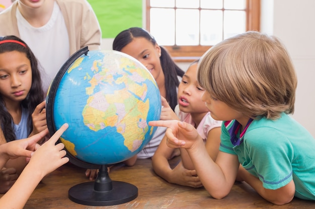 Foto alunos bonitos e professores em sala de aula com globo