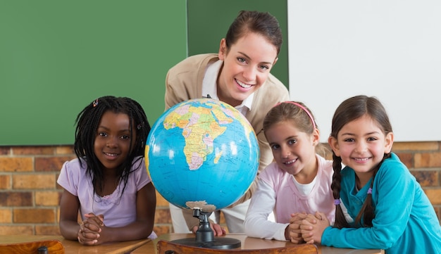 Alunos bonitos e professores em sala de aula com globo