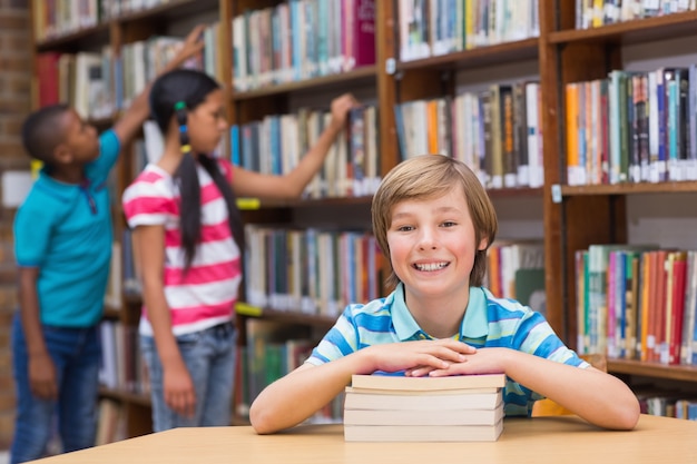 Alunos bonitos que procuram livros em Labrary