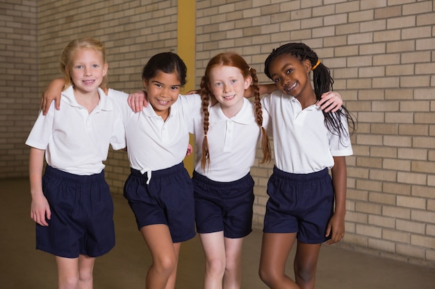 Alunos bonitos sorrindo na câmera em uniforme pe