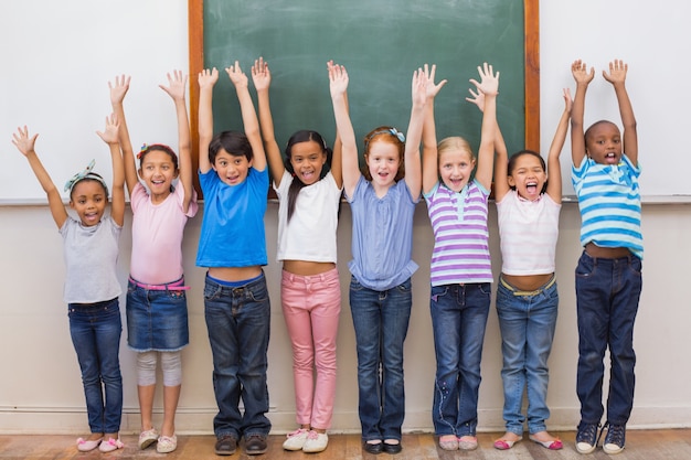 Alunos bonitos sorrindo para a câmera na sala de aula