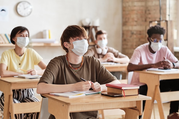 Alunos com máscaras estudando na escola