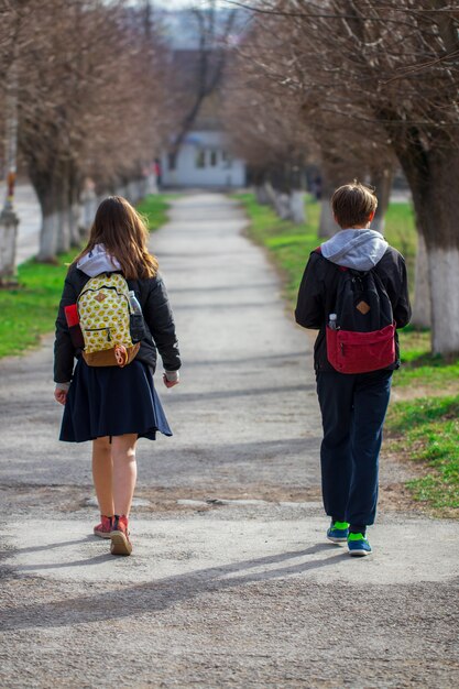 Alunos com mochilas andando na rua