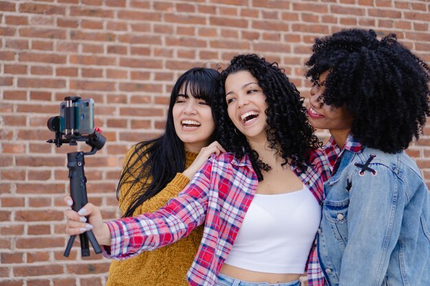 Alunos de intercâmbio gravando um vídeo com um gimbal para enviar uma saudação às suas famílias com seus amigos do campus da universidade