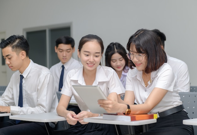 Alunos de uniforme trabalhando com tablet