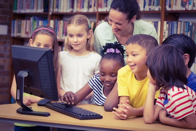 Alunos e professores na biblioteca usando computador