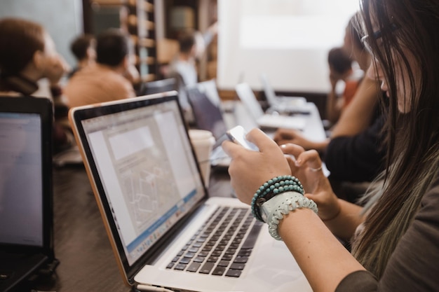 Alunos em sala de aula trabalhando com laptops