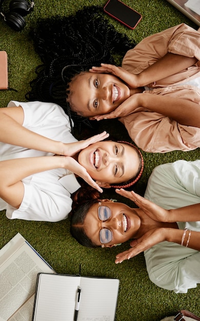 Alunos estudando e diversidade com mulheres jovens felizes deitados juntos mostrando sorriso enquanto na faculdade para educação e aprendizagem Retrato de vista superior de amigas no campus ou na grama da universidade