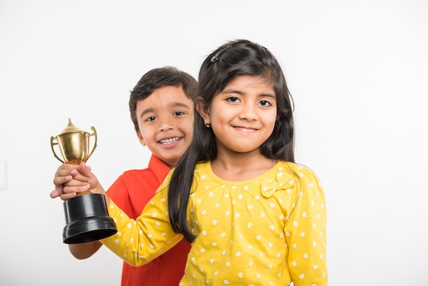 Alunos indianos asiáticos segurando uma taça de troféu de ouro sobre fundo branco