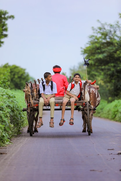 Alunos indianos fofos em um carro de boi