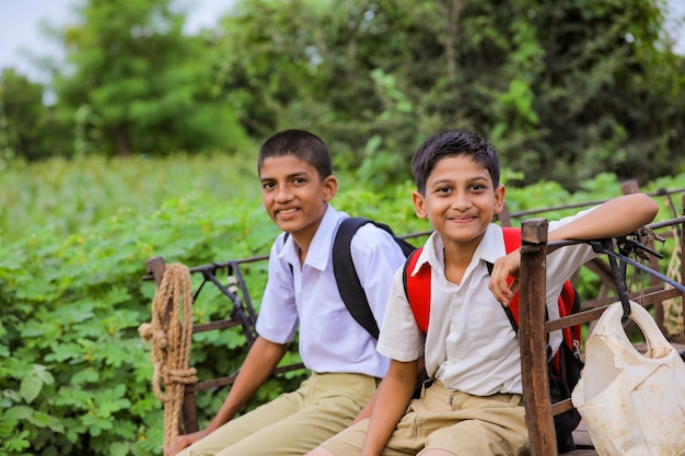 Alunos indianos fofos em um carro de boi