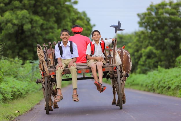 Alunos indianos fofos em um carro de boi