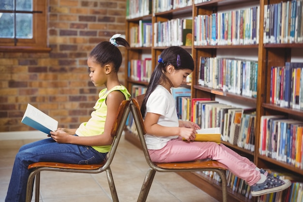 Foto alunos lendo livros na biblioteca