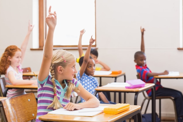 Alunos levantando as mãos durante a aula na escola primária