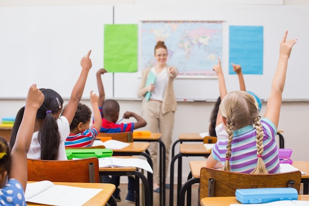 Alunos levantando mão durante a aula de geografia na sala de aula