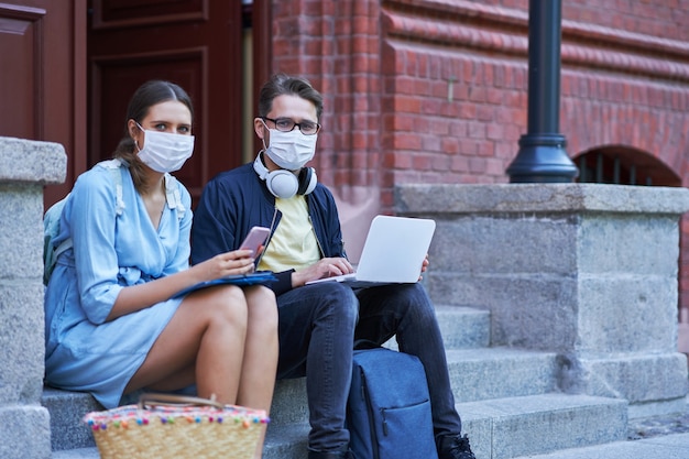 Alunos no campus usando máscaras protetoras e mantendo distância devido à pandemia de coronavírus