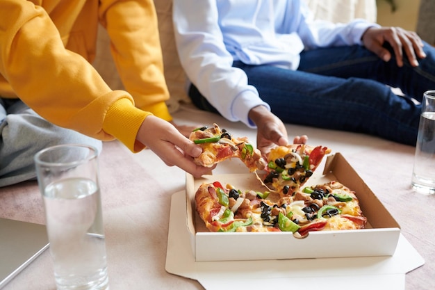 Alunos pegando fatias de pizza