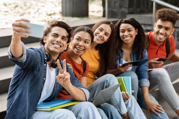 Foto alunos selfie grupo multiétnico de amigos da faculdade tirando foto juntos no smartphone