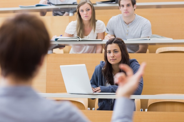 Foto alunos sentados ouvindo o professor