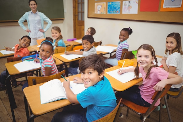 Alunos sorridentes na câmera durante a aula