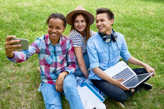 Alunos sorridentes tomando Selfie no parque