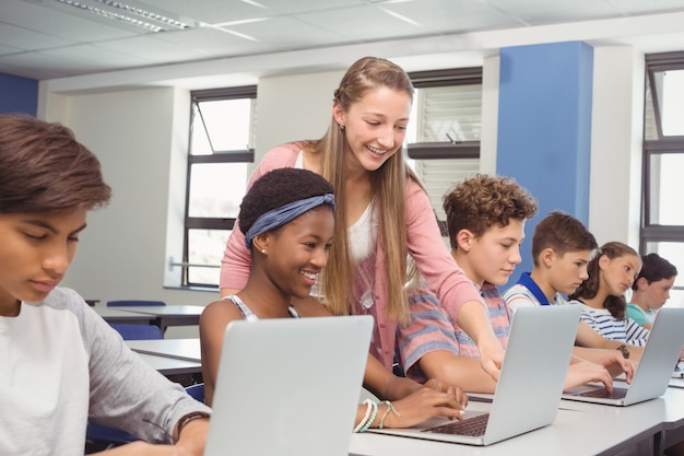 Alunos usando laptop na sala de aula