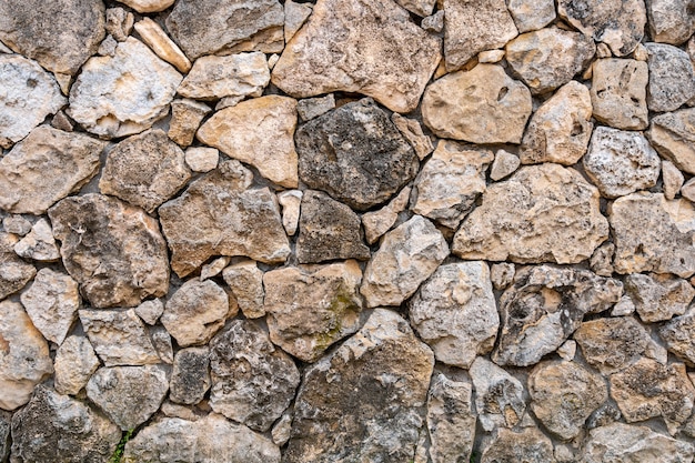 Alvenaria de calcário. a superfície é decorada com material natural. a parede é feita de pedra selvagem.