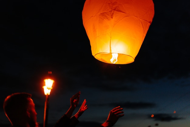 Am Abend, bei Sonnenuntergang, starten Menschen mit ihren Verwandten und Freunden traditionelle Laternen.