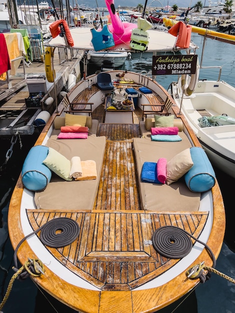 Am Pier festgemachtes hölzernes Ausflugsboot mit farbenfroher Freizeit- und Angelausrüstung