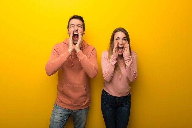 Am Valentinstag Gruppe von zwei Leuten auf gelbem Hintergrund etwas schreien und ankündigen