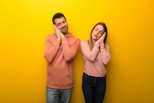 Am Valentinstag Gruppe von zwei Menschen auf gelbem Hintergrund Schlaf Schlafgeste im dorable Ausdruck