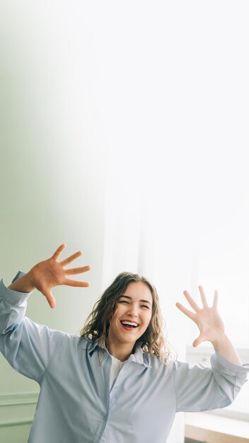 Foto ama de casa alegre divirtiéndose bailando en la sala de estar disfrutando de su tiempo libre en casa mientras los niños están