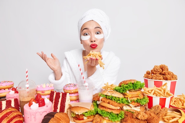 Ama de casa encantadora mantiene palmas con papas fritas sopla aire beso