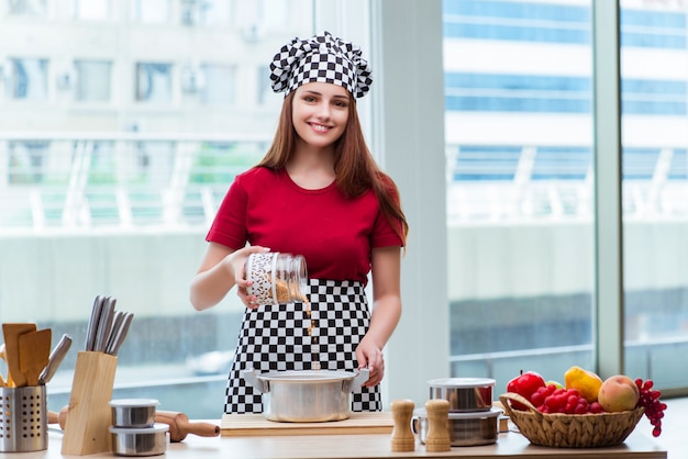 Ama de casa joven que prepara la sopa en cocina