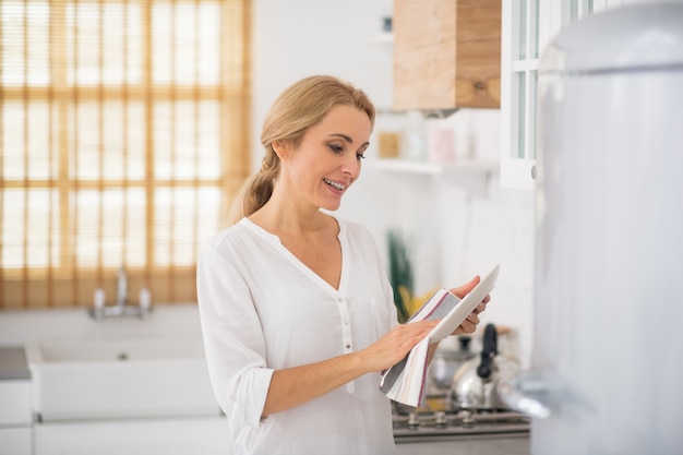 Ama de casa linda rubia limpiando y secando los platos