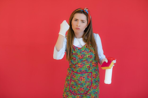 Ama de casa en uniforme con esponja de spray limpia ama de casa o esposa feliz limpiando con botella de jabón