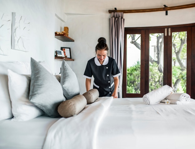 Foto ama de llaves limpiando una habitación de hotel