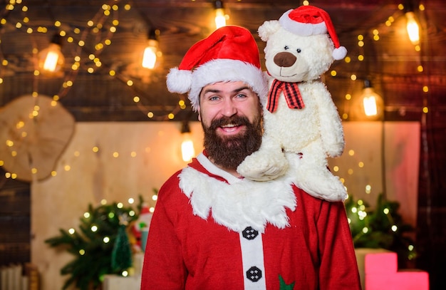 Amabilidad y generosidad Concepto de caridad Hombre barbudo Papá Noel juega con un osito de peluche Caridad de Navidad Ayuda de caridad Difundir alegría felicidad Celebrar el año nuevo Ideas de recaudación de fondos de invierno