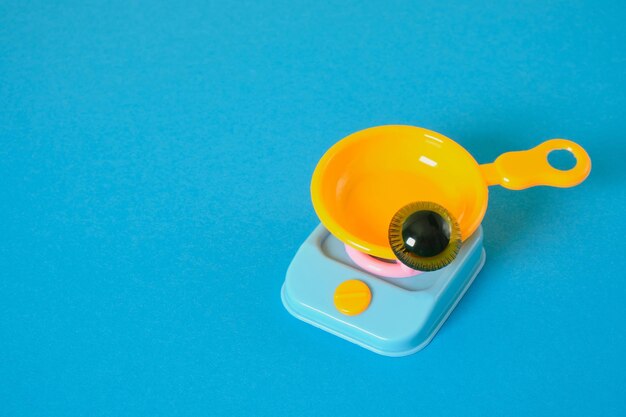 Amable cara divertida concepto ojos de juguete en una bandeja de plástico en una estufa de juguete