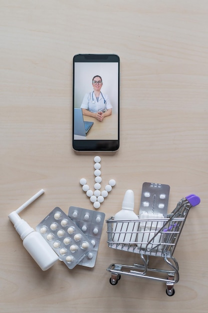 Amable doctora en la pantalla de un teléfono inteligente prescribe tratamiento Medicina en línea Mini trolley con pastillas Consulta remota Farmacia de aplicaciones móviles