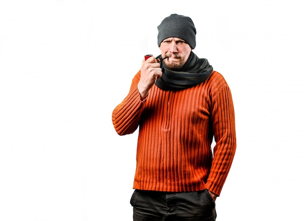 Un amable hombre de mediana edad con barba, con una gorra tejida, fumando una pipa