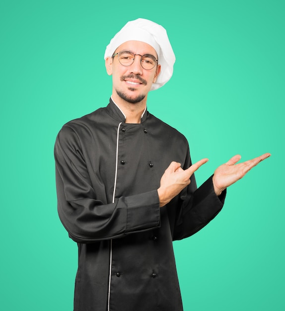 Foto amable joven chef haciendo un gesto de bienvenida