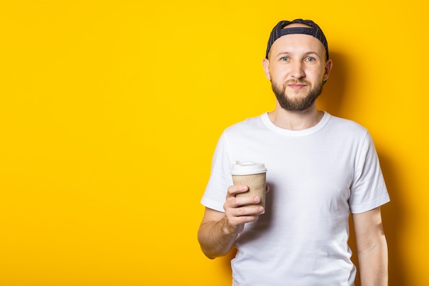 Amable joven sosteniendo una taza de café de papel