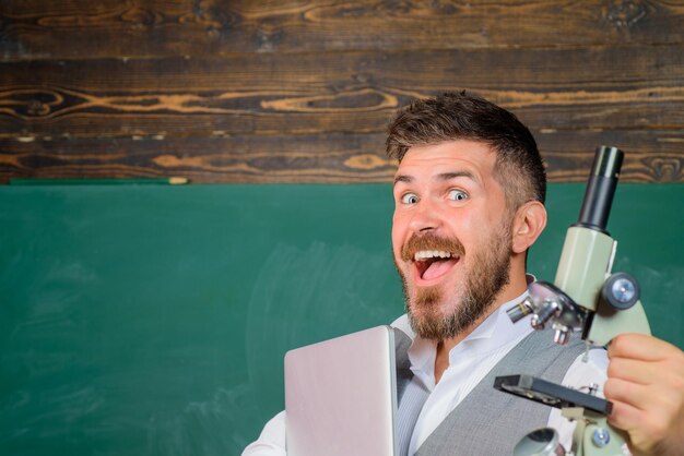 Amable maestro en el aula cerca de pizarra escritorio pizarra copia espacio estudiante preparando examen